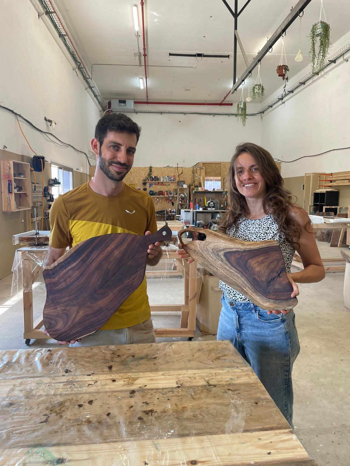 זוג מציגים בוצ'רים מעץ שקמה בעבודת יד בסדנת נגרות