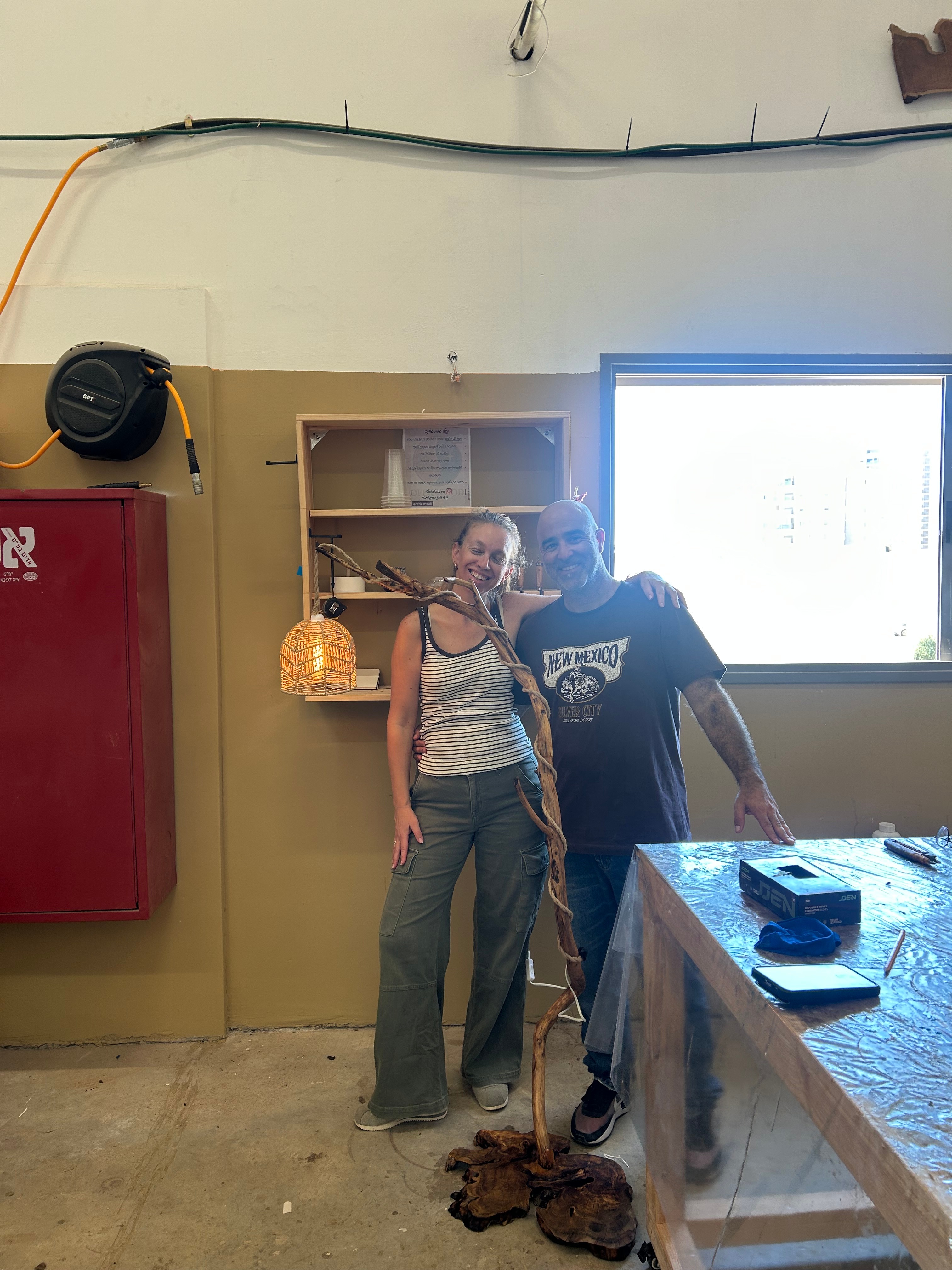 משתתף מציג מנורת רצפה מענף עץ טבעי דולקת שיצר בסדנה